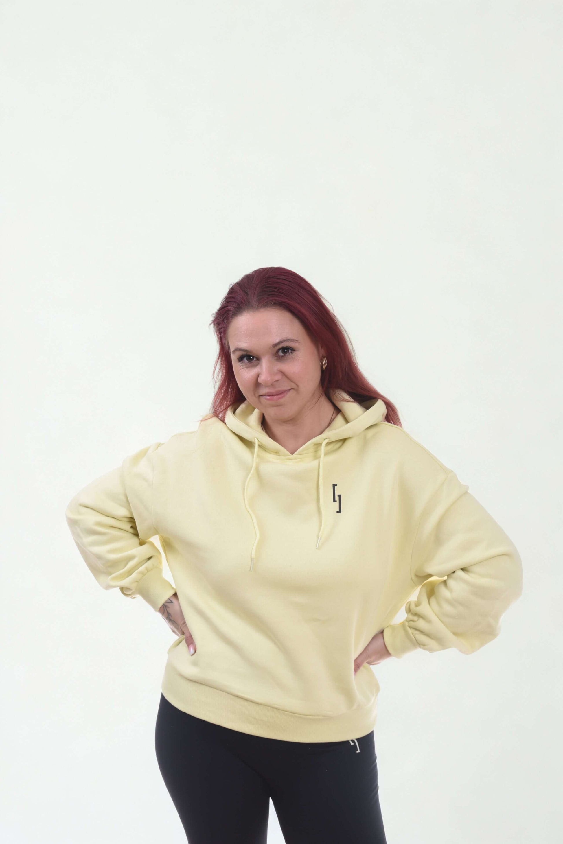 Model wearing a cropped oversized hoodie in yellow from the Raw Line collection.
