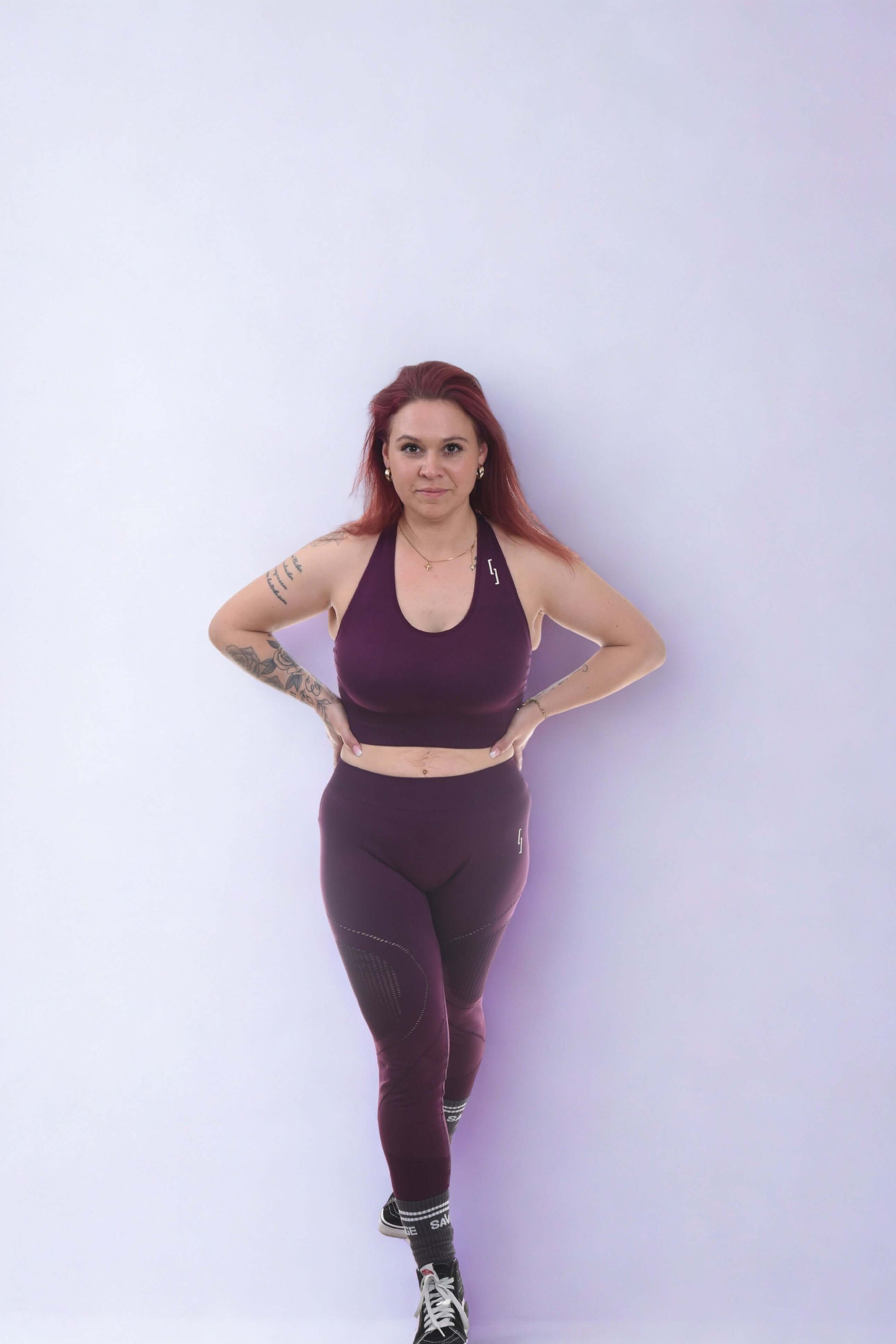 Model wearing performance leggings and sports bra in purple, demonstrating activewear for training.