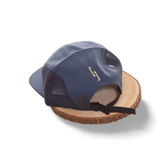 MESH SNAPBACK GYM CAP SAVAGE STYLE on a wooden surface showcasing its breathable design and adjustable closure.