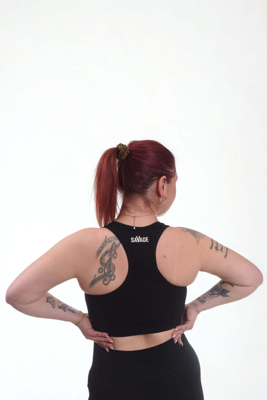 Back view of a woman wearing a black performance sports bra, showcasing seamless design and supportive fit.