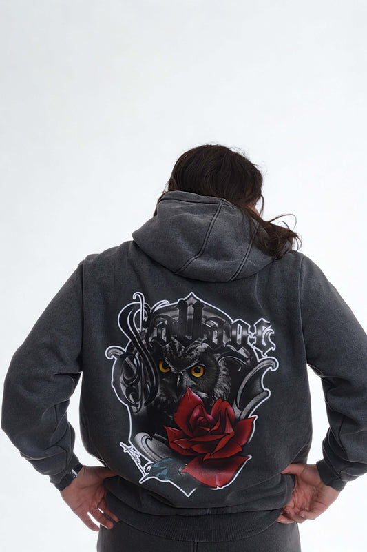 Back view of a man wearing a vintage heavy hoodie men with a graphic of an owl and a rose on it.