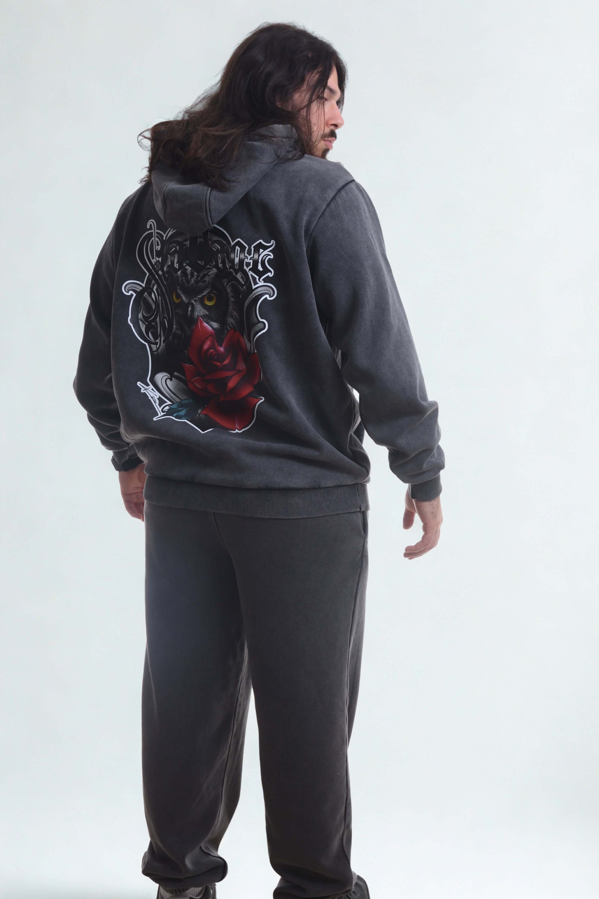 Man wearing a vintage heavy hoodie men with a graphic design on the back showing a rose and lion motif.