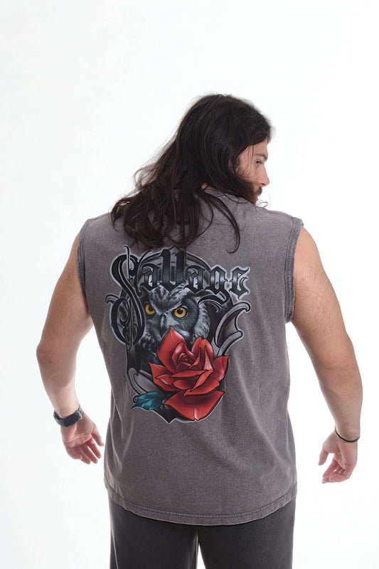 Man wearing a vintage oversized tanktop with graphic design of a rose and an owl on the back, showcasing a rebellious style.
