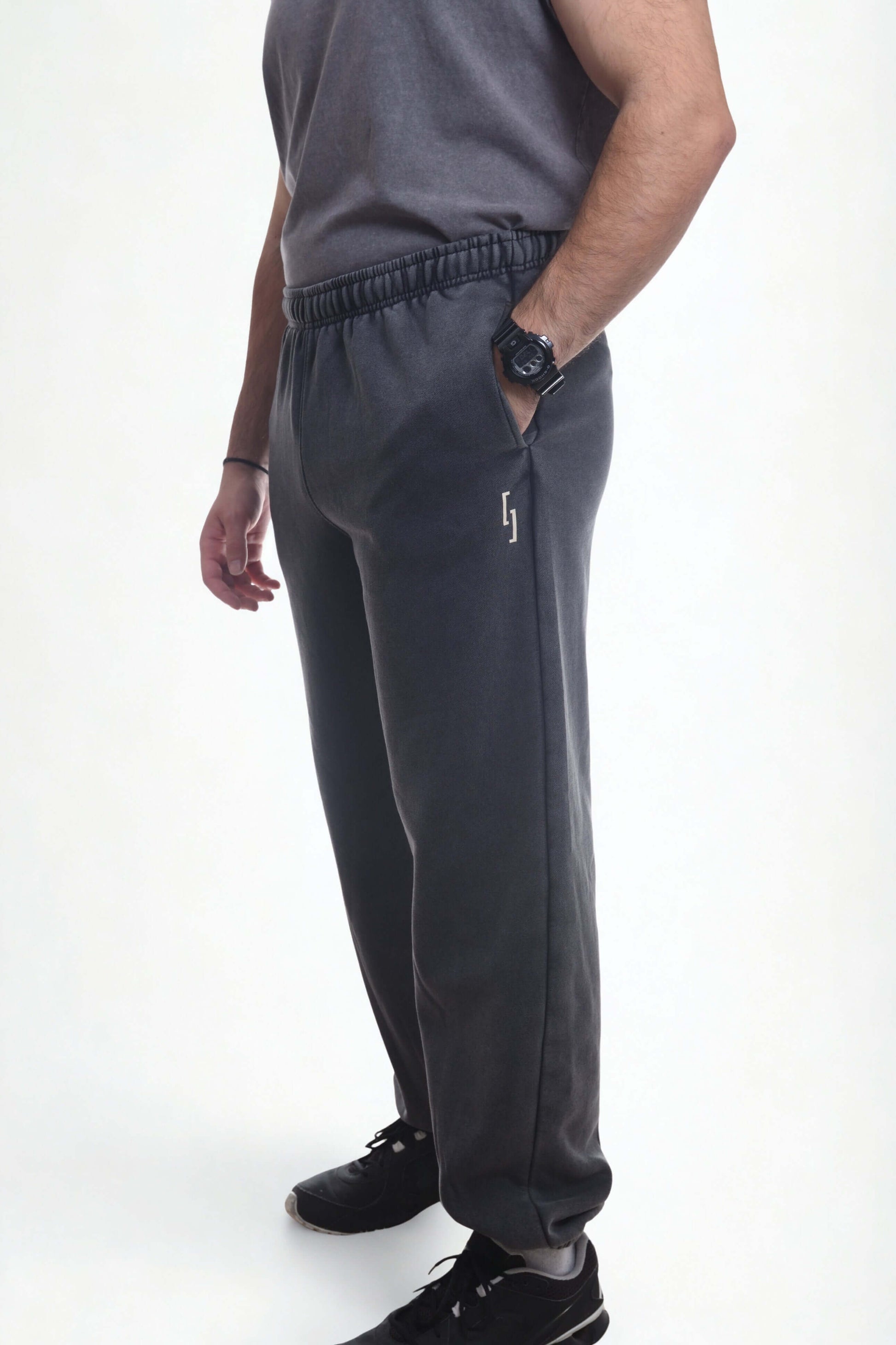 Model wearing vintage ribbed cuff pants in dark gray, showcasing comfort and style for casual and athletic wear.